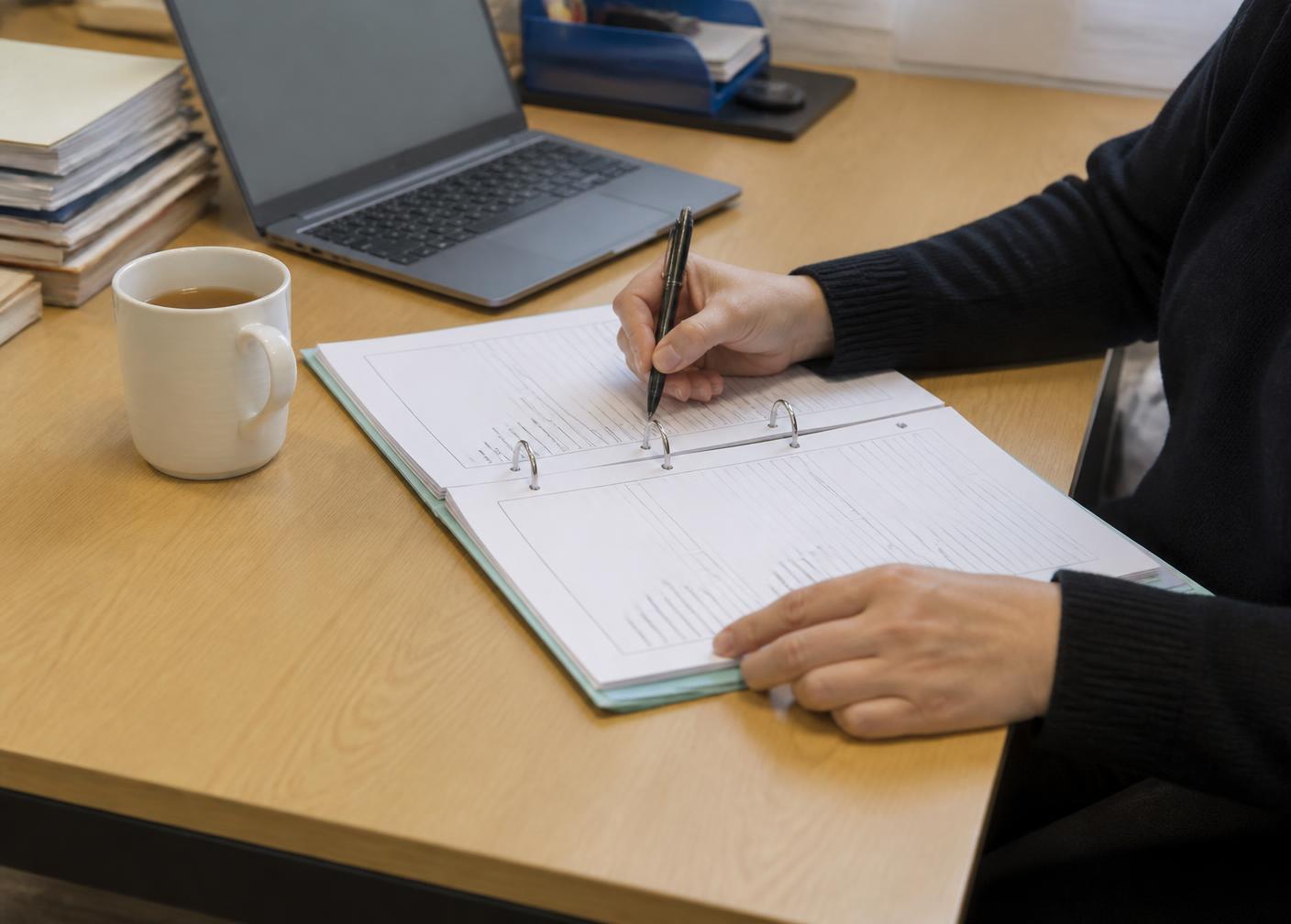 A support professional completing a printed referral form at a desk